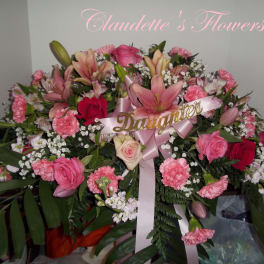 Pink and red floral arrangement with lilies, roses, and carnations