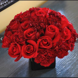 Red rose and carnation bouquet in a black vase