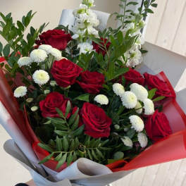 Bouquet of red roses and white flowers wrapped in red and gray paper