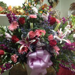 Large mixed bouquet with roses, lilies, and pink gerbera daisies in a vase
