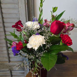 Mixed bouquet of red roses and white carnations in a vase