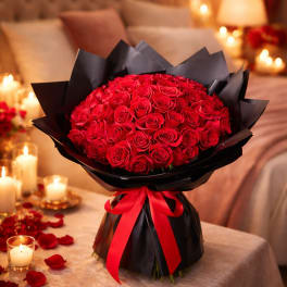 Bouquet of red roses wrapped in black paper with a red ribbon
