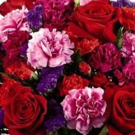 Bouquet of red roses and pink carnations with purple filler flowers