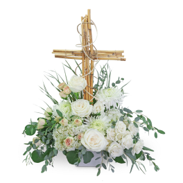 White floral arrangement with a wooden cross centerpiece