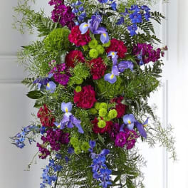 Tall standing floral spray with blue, purple, and pink flowers