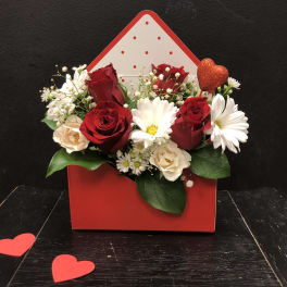Red and white rose bouquet in a red heart-shaped box with a glitter heart pick