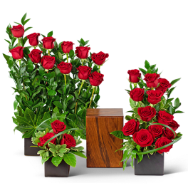 Red roses arranged in black square vases with a wooden cube centerpiece