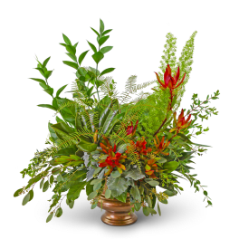 Tropical floral arrangement with red-orange blooms in a bronze vase