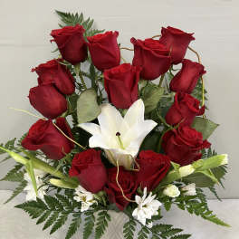 Red roses and white lilies arranged in a white vase