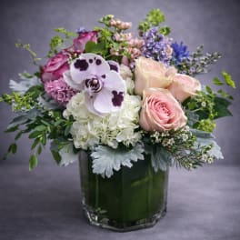 Pink roses and orchids in a glass vase