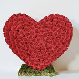 Heart-shaped arrangement of red roses on a moss base