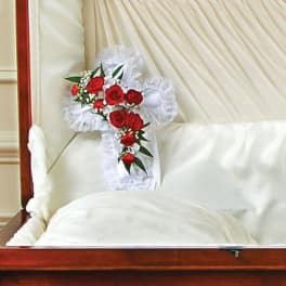 Red rose spray on a white satin pillow