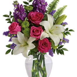 Pink roses and white lilies in a clear glass vase