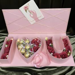 Pink gift box with rose-shaped flowers and gold chocolates