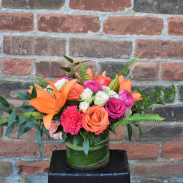Orange lilies and pink roses in a glass vase