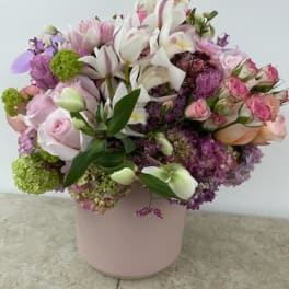 Pink and white mixed flower arrangement in a pale pink vase