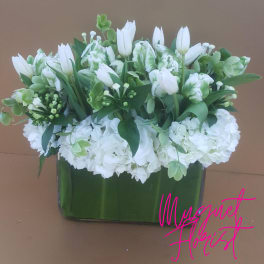 White tulips and hydrangeas arranged in a rectangular glass vase