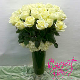 Bouquet of pale yellow roses in a tall green vase