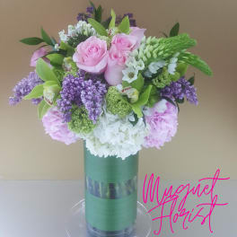 Pink and white floral arrangement in a tall glass vase