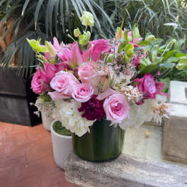 Pink roses and lilies arranged in a green vase