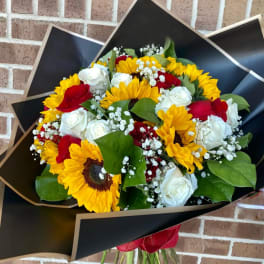 Bouquet of sunflowers, red and white roses, and baby's breath in black wrap