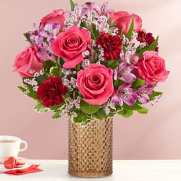 Pink roses and red carnations in a textured vase