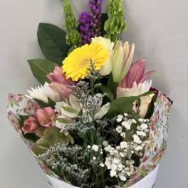Mixed bouquet with pink lilies, yellow gerbera, and white filler flowers