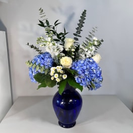 Blue and white floral arrangement in a cobalt vase