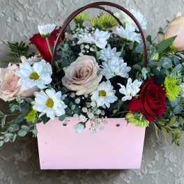 Mixed bouquet of roses and daisies in a pink handled box