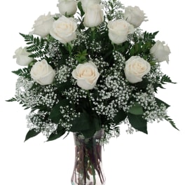 White roses and baby's breath in a clear glass vase