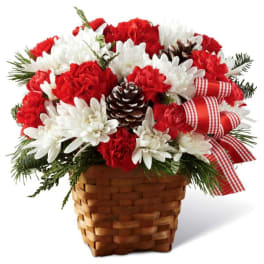 Red and white flowers in a woven basket with a plaid ribbon