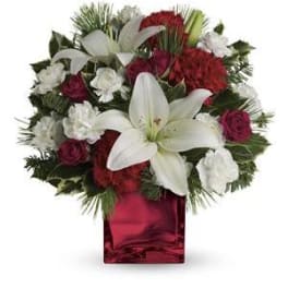 Red and white floral arrangement in a red glass vase