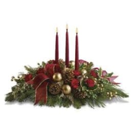 Holiday centerpiece with three red candles and evergreen accents