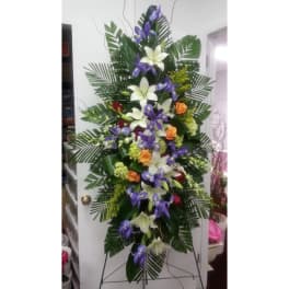 Tall floral standing spray with white lilies, purple orchids, and orange roses
