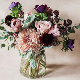Bouquet of pink and purple flowers in a clear glass vase