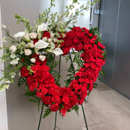 Large red and white floral wreath on a stand
