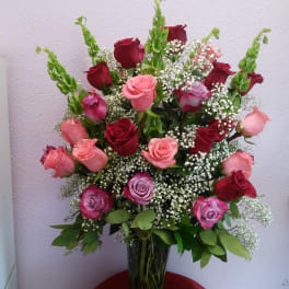 Mixed roses in a clear glass vase with baby's breath