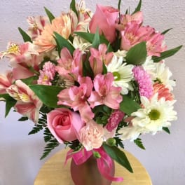 Pink and white mixed bouquet in a vase with a ribbon