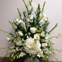 White floral arrangement with calla lilies, roses, and hydrangeas in a vase