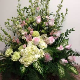 Tall floral arrangement with pink roses and pale hydrangeas