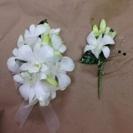 White floral corsage and boutonniere with ribbon accents