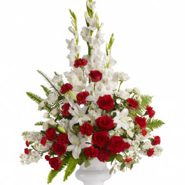 Red roses and white lilies in a white urn vase