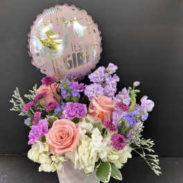 Pink and lavender flower arrangement with a "It's a Girl" balloon
