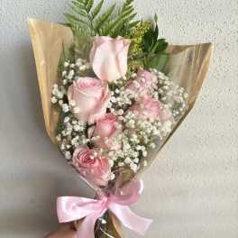 Bouquet of pink roses with baby's breath and a pink ribbon