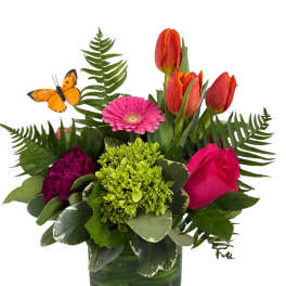 Mixed bouquet in a square glass vase with tulips, a gerbera daisy, and a rose