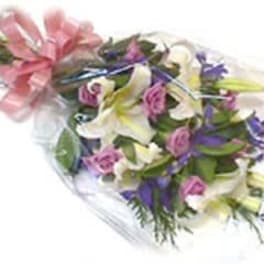 Bouquet of white lilies, pink roses, and purple flowers wrapped in clear plastic