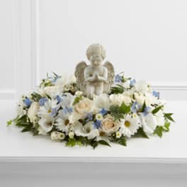White floral arrangement with an angel figurine centerpiece