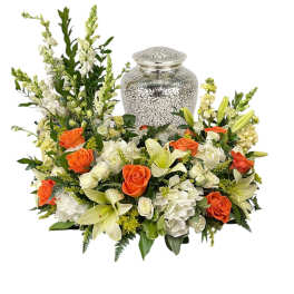 Floral funeral urn arrangement with orange roses and white lilies