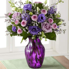 Purple and pink mixed bouquet in a purple glass vase
