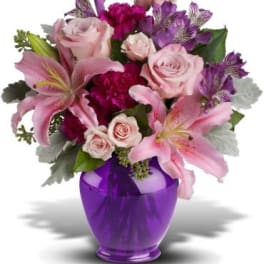 Pink lilies and roses in a purple vase